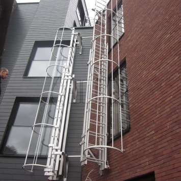 JOMY vaste vluchtladders met veiligheidskooi volgens de voorgeschreven normen. Onze veiligheidskooien zijn ook gemaakt uit geanodizeerd aluminium and deze hebben een erg strak uiterlijk en zijn daarnaast uiterst sterk en betrouwbaar. Dit is de ideale vluc JOMY Vluchtladder of brandladder. De meest economische vluchtladder is de vaste ladder met veiligheidskooi zoals voorgeschreven. JOMY maakt deze evacuatieladders nu reeds meer dan 40 jaar en past ze aan, aan iedere specifieke situatie.